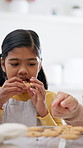 Eating, baking and family with cookies in kitchen at house for sweet treat, snack or bonding. Happy, growth and girl child with grandmother for enjoying biscuits for dessert with development in home.