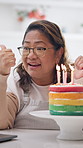 Woman, count and birthday cake in home with video call, sing and virtual chat for celebration. Smile, mature person or laptop at house with dessert, online party and blow candles for special occasion