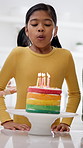 Family, child and blowing candles on birthday cake with grandmother, kiss and mom embrace for support. Girl, applause and milestone celebration in home with mother, grandparent and hug with dessert.