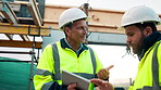 Engineer, men and talk on construction site with tablet, manager advice or collaboration for project. Engineering, people and research outdoor with tech, infrastructure and discussion for renovation.
