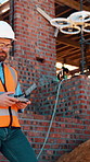 Construction, review or engineer on site with drone, structure or progress track in architecture check. Assessment, contractor or man with tech, industrial evaluation or process in remote inspection.