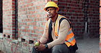 Lunch, break and man at construction site with thinking, fruit snack and PPE for building project. Black person, reflection and eating apple outdoor with helmet, industrial job or infrastructure plan