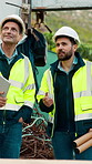 Construction, team and men talking for inspection, project feedback and building development. Engineer, planning and smile outdoor for infrastructure progress, tablet or safety evaluation on site