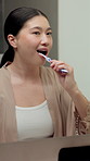 Bathroom, brushing teeth and Asian woman in mirror for dental hygiene, gum disease and oral care. Reflection, morning and person with toothbrush for wellness, cleaning and fresh breath in home