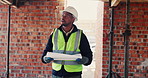 Walking, black man and blueprint on construction site for inspection, infrastructure and property. Architecture, civil engineering and worker for building safety, renovation and remodeling project