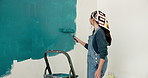 Back, painting and woman in home with wall, interior design and diy project for renovation. Painter, female person and paintbrush at house for remodeling, property makeover and household improvement
