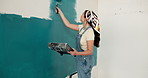 Tray, painting and woman at house with wall, interior design and diy project for renovation. Painter, female person and paintbrush in home for remodeling, property makeover and household improvement