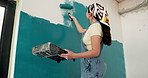 Woman, roller and painting in home with interior design, renovation project and property makeover. Low angle, back and creative person with art tools for house improvement, diy or remodeling process.