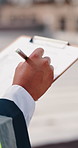 Hands, engineer and writing in city with clipboard, inspection and quality control for construction. Person, notes and checklist report for architecture, urban evaluation and information on project