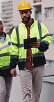 Construction, walking and people on tablet on rooftop for building inspection, meeting and planning. City, team and workers with tech, papers and discussion for engineering, maintenance and project