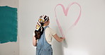 Woman, heart and mural art with paint on wall for nursery, love or fun activity for home decor. Female person, painter or shape with romantic gesture or symbol for interior design or style in house