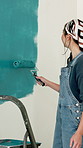 Woman, happy and painting wall with brush for creativity, self expression and therapeutic hobby. Process, personalisation and home decor with diy project, interior design and paint for renovation