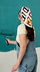 Woman, back and painting wall with brush for creativity, self expression and hobby for fun. Process, maintenance and home decor with diy project, interior design and paint for renovation and artist