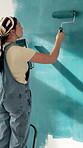 Woman, back and painting wall with brush for creativity, therapeutic hobby and interior design. Process, artist and home decor with diy project, maintenance and paint for renovation and inspiration