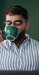 Coffee, laptop and reading with man in home living room for planning, remote work or research. Agenda, computer and drink with freelance employee in apartment for digital feedback, report or review