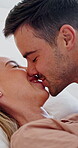 Couple, kiss and bonding on bed, home and fun with partner on break and laughing together in bedroom. Love, connection and affection for spouse, smile and happy people on weekend or playful in house