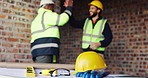People, helmet and high five on construction site with equipment, certified safety and project success. PPE, happy men and celebration in building for engineering goals, hard hat and collaboration.