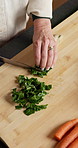 Hands, cooking and person with vegetables on chopping board for healthy diet, wellness or nutrition. Cut ingredients, woman and meal prep with knife at home, organic and vegan in kitchen from above