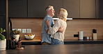 Love, dance and old couple in home for support, comfort or bonding together in kitchen. Smile, commitment and senior man with woman for romance with marriage, anniversary and embrace in apartment