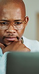 Thinking, black man and reading in home with laptop, research and finance report for mortgage. Male person, planning or house with pc for email, review budget and loan application for household bills
