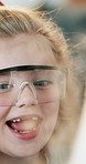 Goggles, excited and child in home with science project, assignment or homework in house. Wow, student and girl kid with safety equipment for education with discovery in apartment for growth.