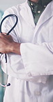 Arms crossed, hands and stethoscope with doctor in hospital for health or medical wellness. Confidence, consulting and trust with healthcare professional man in clinic for appointment or checkup