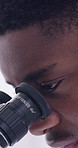Black man, scientist and lens in lab with microscope, research or medical study for experiment. Male person, inspection and biotechnology for liquid testing, specimen analysis and vaccine development