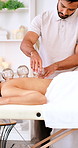 Woman, sleep and cupping therapy in spa with chiropractor, holistic health or healing muscle tension. Person, relax and worker with glass suction tools for blood circulation, injury recovery or detox