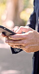 Hands, phone and typing with business man outdoor in park for communication, scrolling or search. App, social media and text message with employee in nature for connectivity, post or profile update