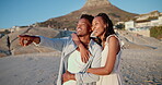 Hug, black couple and pointing on holiday at beach for romantic getaway, sightseeing and scenery. Vacation, love and happy people with bonding on sand for exploring, sea view and healthy relationship