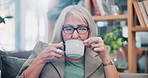 Coffee, thinking and house with senior woman for vision, calm morning and peace in living room. Serious, elderly person and relax on couch with herbal beverage, remember memory and reflection in home
