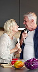 Cutlery, food and sing with old couple in kitchen of home together for bonding or meal prep. Cooking, dance and microphone with senior people in apartment for fun, healthy eating or laughing