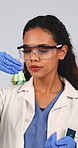 Scientist, beaker and liquid in studio for chemistry, research and medical study with experiment. Thinking, woman or goggles with observation, chemical reaction and testing sample on white background