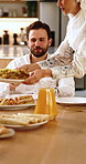 Muslim, couple and serving in home with food, healthy meal and bonding together for Eid lunch. People, plate or feast in dining room with cuisine, nutrition diet and celebration for Islamic tradition