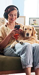 Headphones, phone and woman with dog on sofa for online streaming, music and relax together on weekend. Home, happy and person on mobile app for connection, radio and bonding with pet in living room