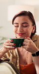 Happy, aroma and woman with coffee on sofa for wellness, calm and peaceful on weekend morning. Home, thinking and person with caffeine drink for reflection, good mood and satisfaction in living room