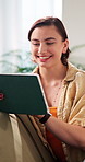 Typing, happy and woman on sofa with tablet for social media, streaming app and connection. Smile, home and person on digital tech for internet, website and sign up for movie subscription on weekend