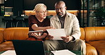 Budget, documents and tablet with interracial couple on sofa in home living room for planning. Finance, paperwork and technology with mature people in apartment for investment discussion or review