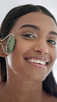 Woman, face and jade roller in bathroom for dermatology, lymphatic drainage and massage in home. Cosmetics, facial treatment and gua sha with stone tool for beauty, anti aging and blood circulation