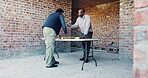 Building, meeting and planning with men on construction site for collaboration or development. Blueprint, conversation and engineering with architecture team on worksite for decision or discussion