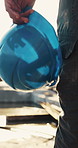 Hand, builder and walk with helmet at construction site for safety or infrastructure development. Architect, hard hat and legs of person outdoor with protection gear, flare or engineering compliance
