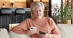 Phone, credit card and woman in home for payment, online shopping or fintech for digital money. Mobile, debit and mature person in living room for ecommerce, internet banking and investment app