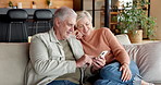 Couple, talking and phone in home at smile, love and browsing website for bonding together. Happy, mature people and discussion at house with mobile app, social media and streaming for weekend break
