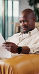 Finance, happy and black man with documents on sofa for budget planning, expenses or mortgage bills. Male person, reading or checking financial invoices for insurance policy or asset management