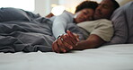 Couple, love and holding hands on bed, home and bonding with partner in bedroom, cuddle and support. Black people, sleeping and resting with spouse in house, affection and commitment for relationship