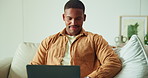 Man, research and remote work on sofa with laptop, browsing website and check trends for copywriting. Freelance copywriter, black person and reading in home with computer, ad campaign and creativity.