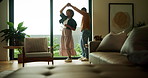 Couple, dance and holding hands in lounge, house and bonding with partner on anniversary or spinning. Black people, home and forehead touch with spouse, rhythm and happy for relationship milestone