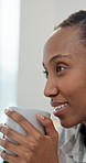 Woman, thinking and drinking coffee in home with calm morning routine, wellness or relax on weekend. Happy, black person and chill in apartment with warm beverage, reflection or cozy on peaceful day.
