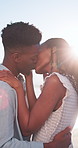 Kiss, beach and hug with black couple for love, romance and honeymoon for vacation or travel. Sunshine, holiday and man with woman for happiness, marriage and seaside with relationship and smile