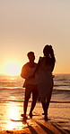 Sunset, travel and holding hands at beach with couple, adventure and affection on holiday. Space, people and walking at sea with evening horizon, romantic date and bonding together on vacation trip